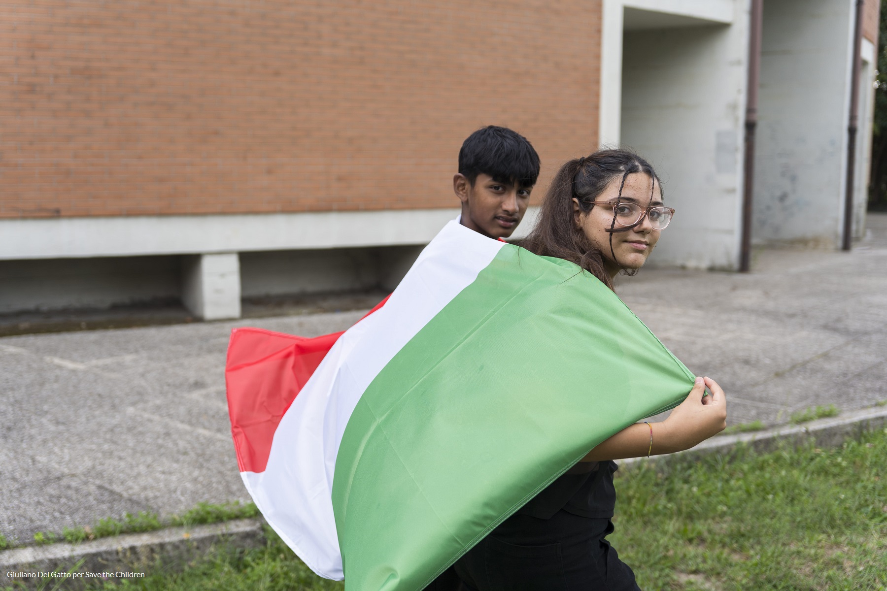 ragazzo e ragazza con bandiera dell'Italia sulle spalle