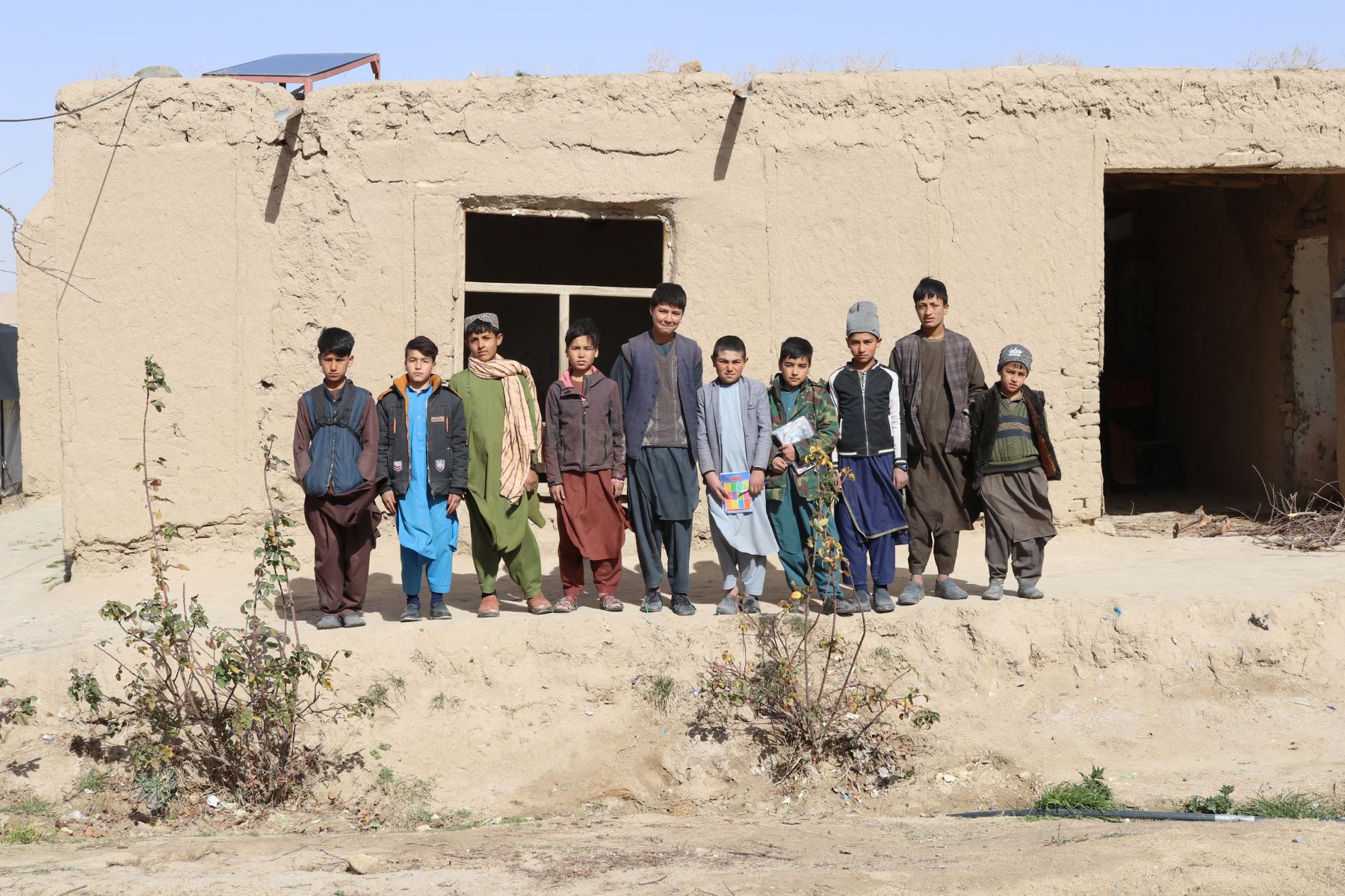 Gruppo di ragazzi in Afghanistan in piedi per ritratto di gruppo 