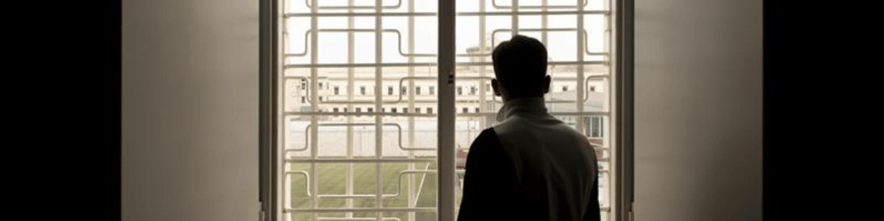 Ragazzo di spalle di fronte ad una finestra