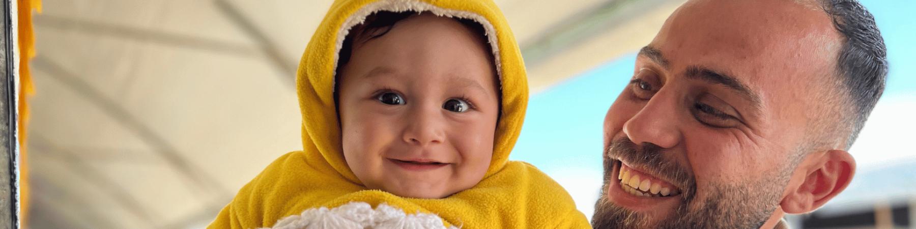  Sameer, 6 mesi, con Ali, staff di Save the Children, durante la distribuzione di kit per bambini a Gaza