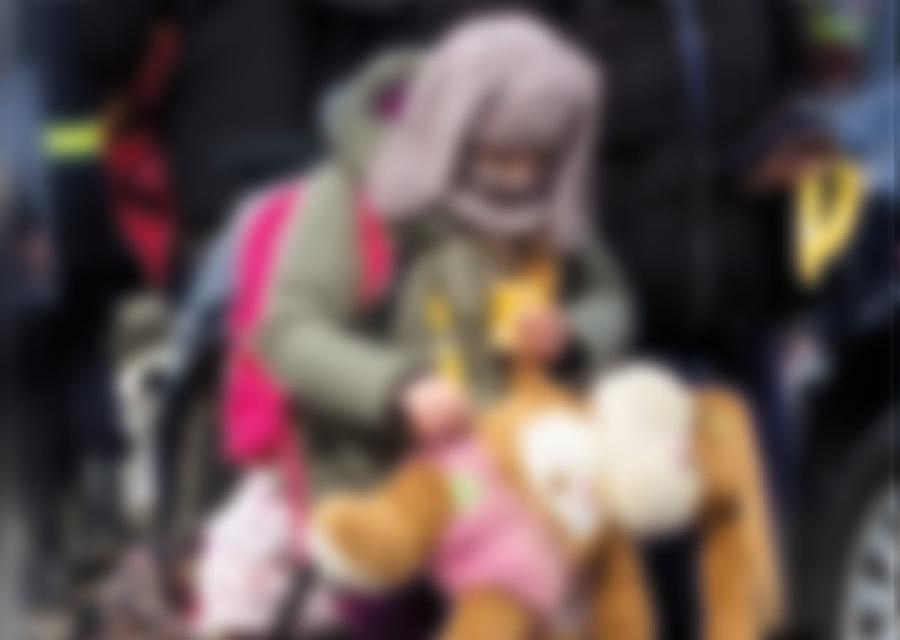 bimba con in braccio un peluches e uno zainetto in spalla cammina insieme a degli adulti, è inverno 