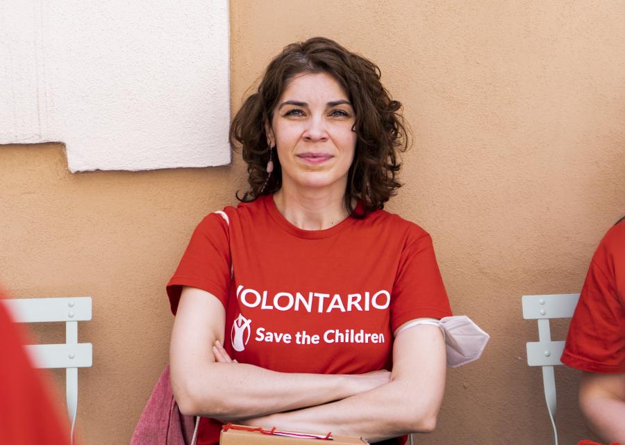 ragazza volontaria con maglietta save the children che posa con mani incrociate sul petto