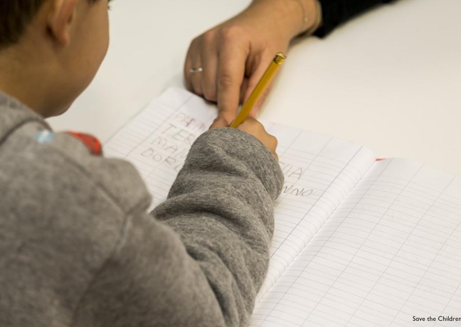 dettaglio su bambino che scrive su un foglio