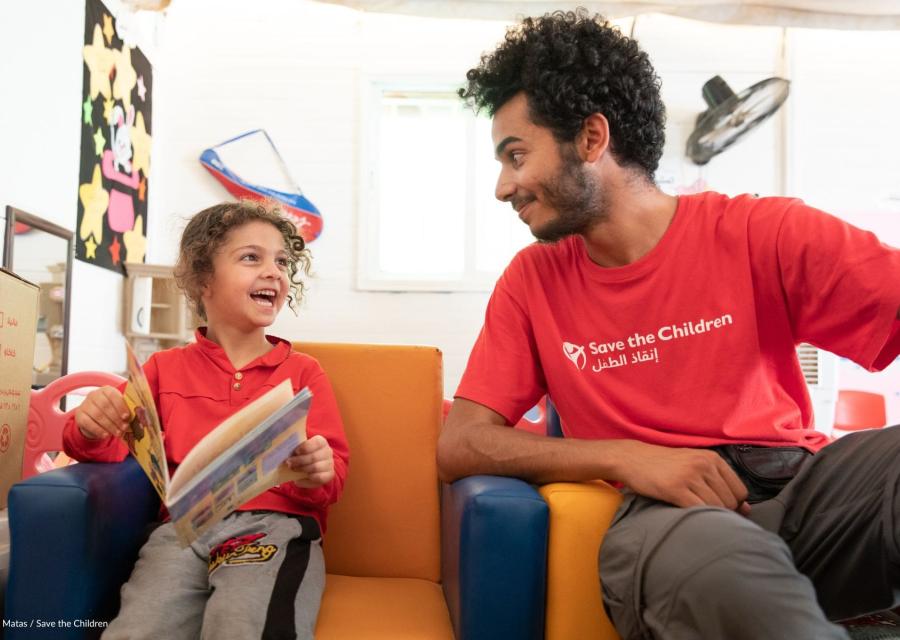 bambina che ride con operatore save the children in early learning centers al campo Zaatari in Giordania