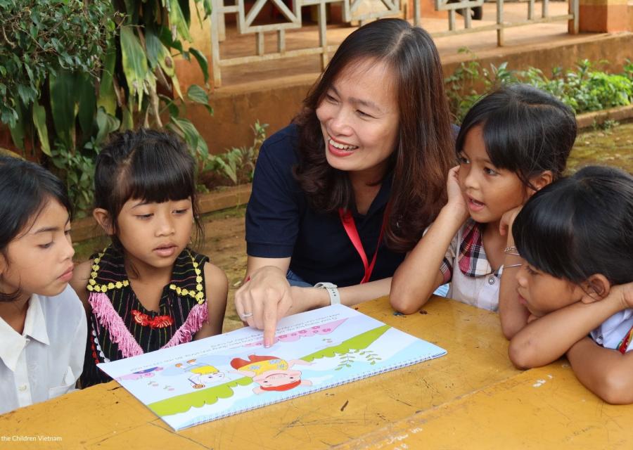  Bambini e operatrice Save the children in Vietnam mentre studiano 