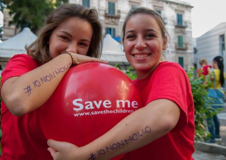 ragazze volontarie sorridenti che abbracciano un palloncino 