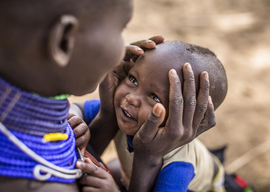 mamma tiene il viso del suo bambino sorridente tra le mani