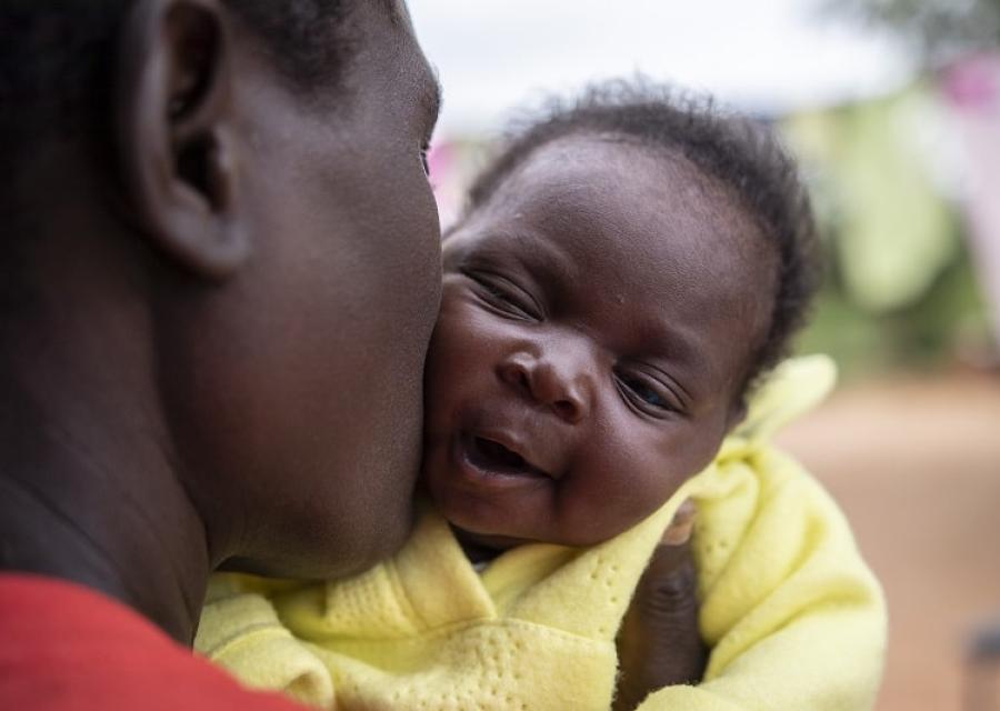 mamma nera che bacia la sua bimba neonata sulla guancia