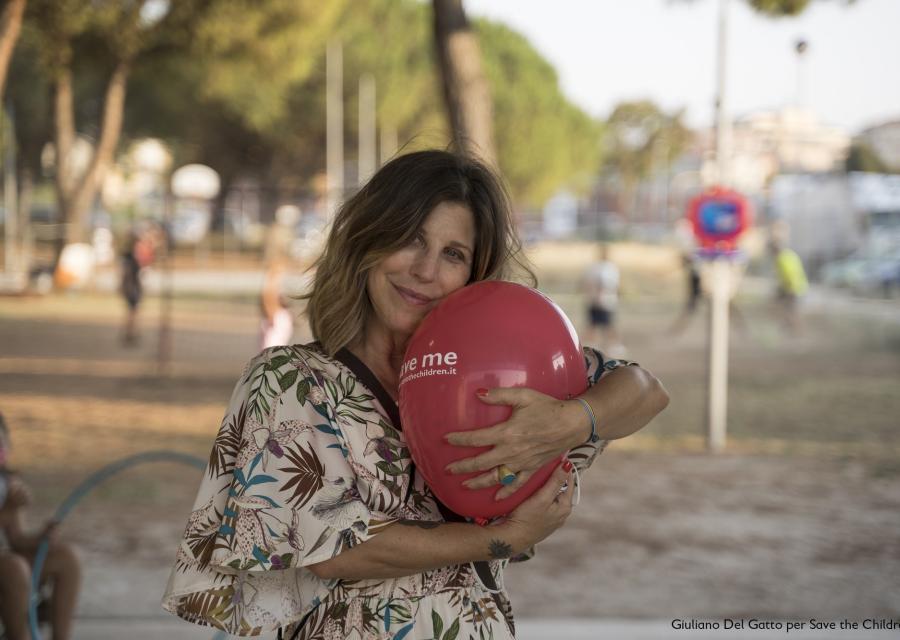 Michela Andreozzi in primo piano mentre abbraccia un palloncino rosso