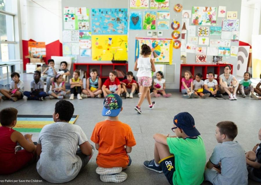 bambini seduti in cerchio per svolgere delle attività di gioco