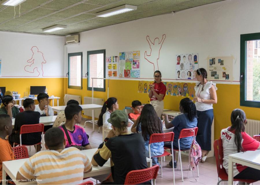 ragazzi seduti sui banchi di scuola per orientamento scolastico mentre ascoltano l'insegnante 