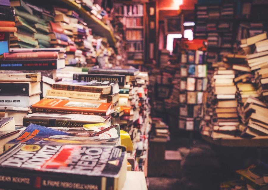 stanza piena di libri colorati impilati 