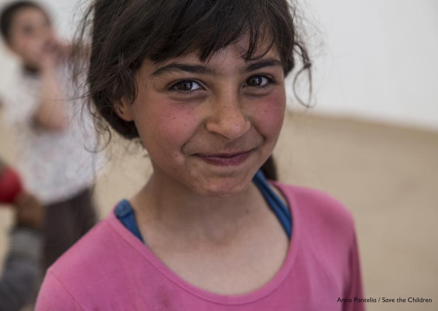 primo piano bambina mora e sorridente con maglietta rosa