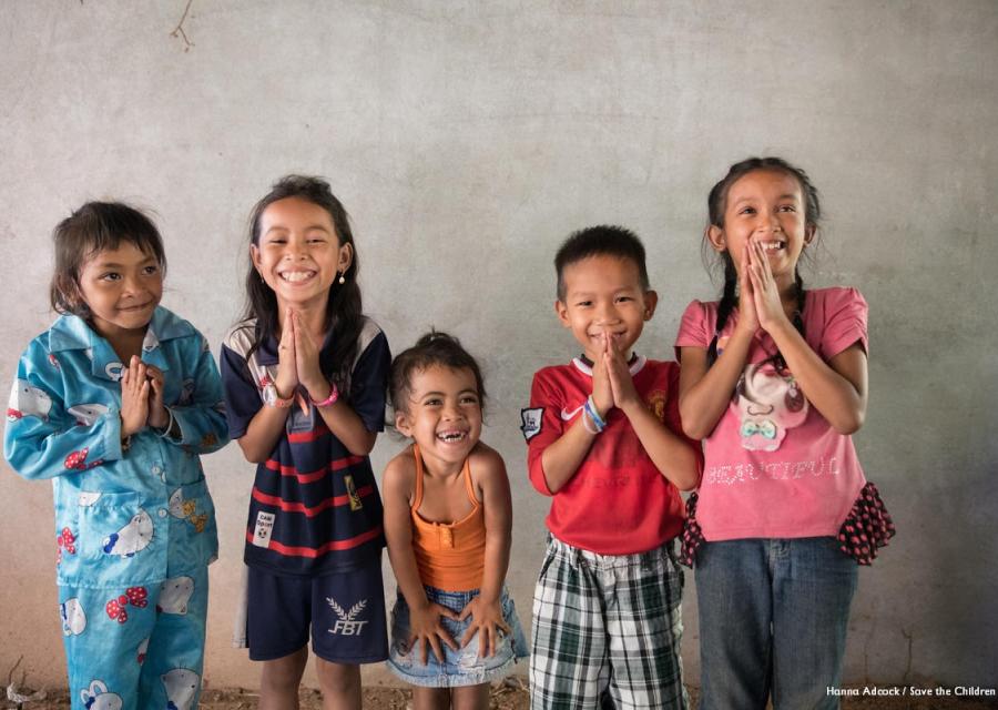 5 bambini cambogiane in piedi con le mani giunte sorridono
