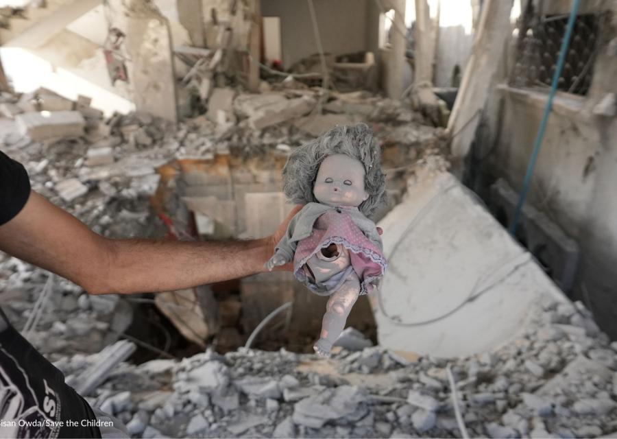 peluche di una bambola sopra le macerie a Gaza senza un arto