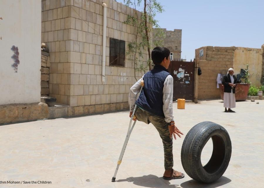 bambino senza una gamba in Yemen in piedi con una stampella 