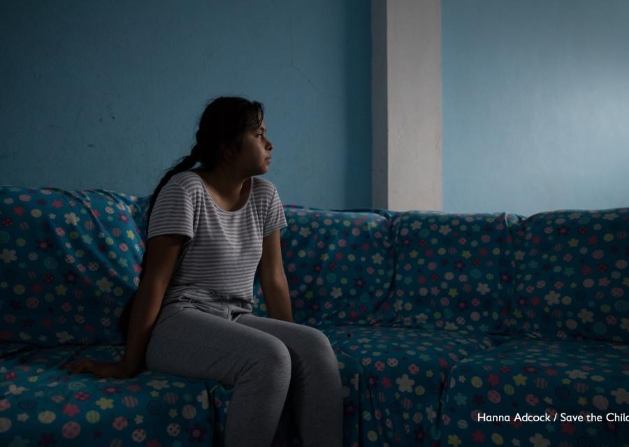 Ragazza in penombra di profilo seduta su un divano