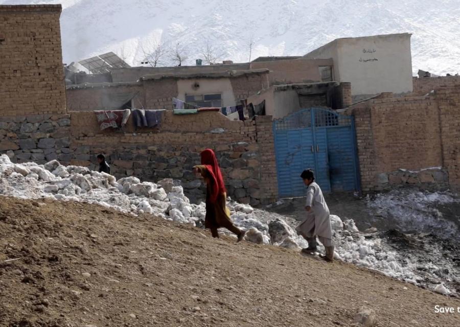 Due bambini afghani camminano in salita all interno del loro villaggio