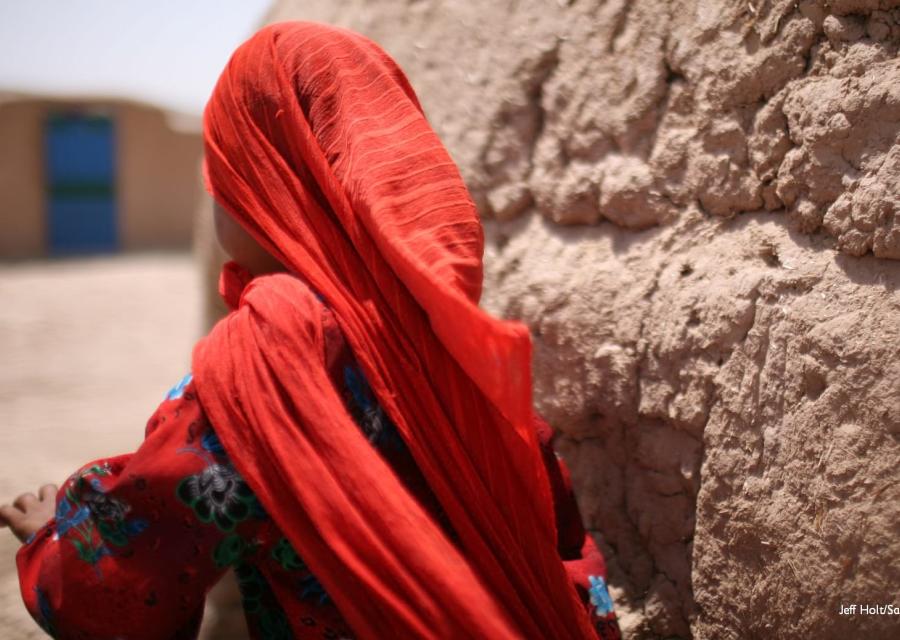 Bambina afghana di spalle con foulard rosso
