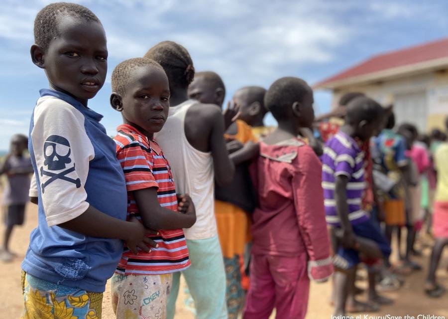 Bambini ugandesi in fila uno dietro l altro all aperto