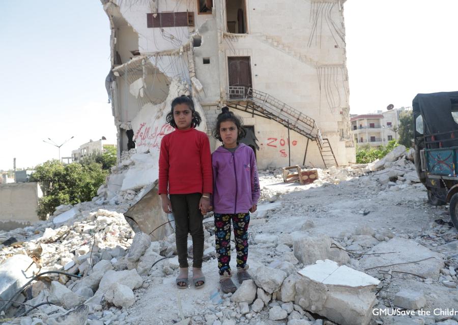 Due bambine siriane in piedi tra le macerie