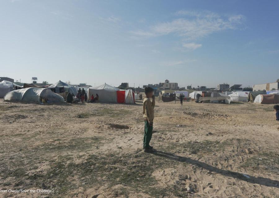 Ragazzo in piedi davanti alle tende a Gaza