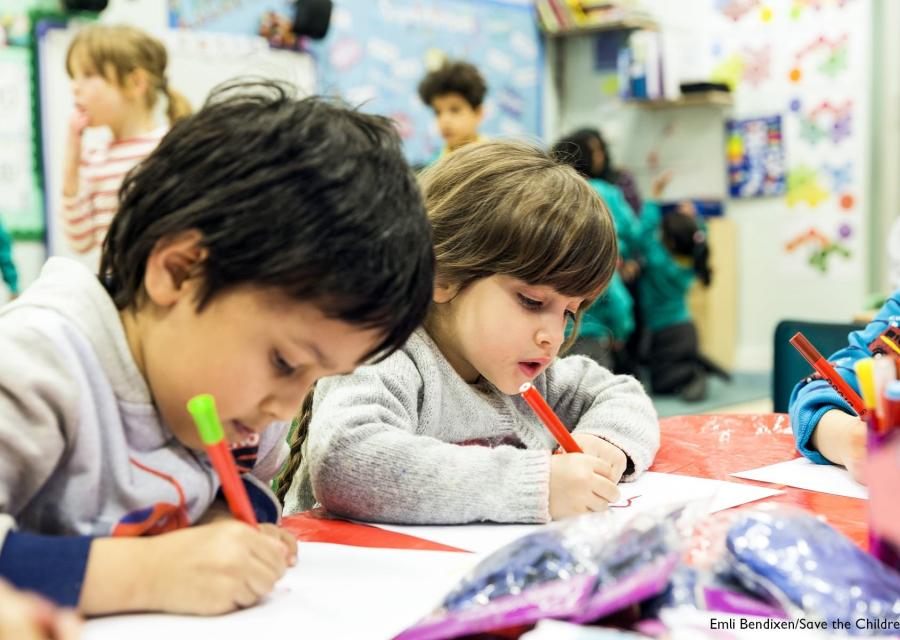 due bambini di 5 anni disegnano con matite seduti a tavolino