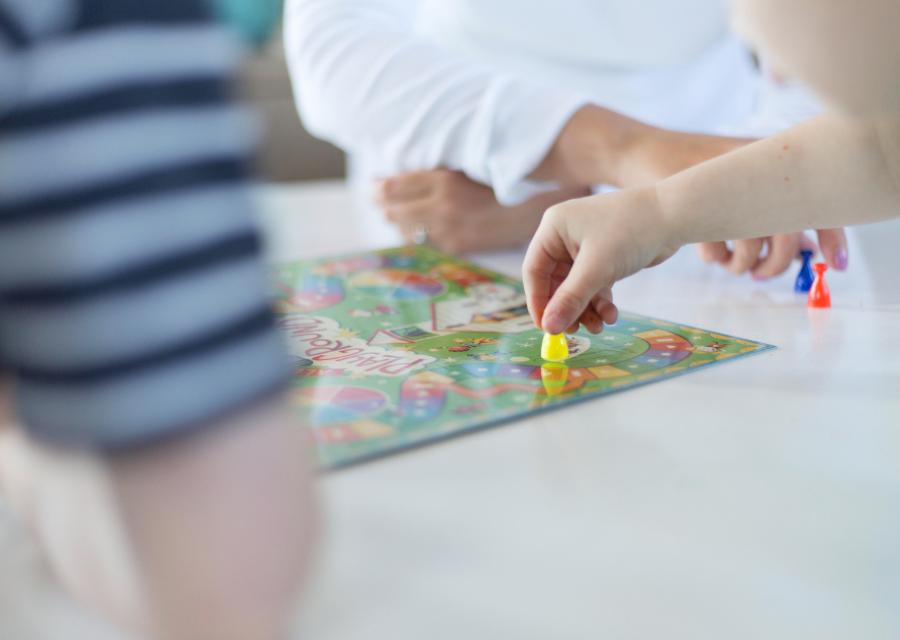 primo piano gioco da tavolo con mani dei bambini che spostano pedine