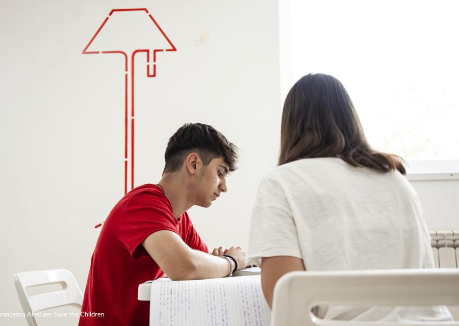 ragazzo che studia con ragazza di spalle 