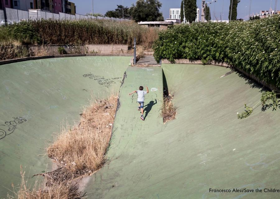 Un bambino di spalle corre in uno degli spazi abbandonati di Ponte di Nona a Roma