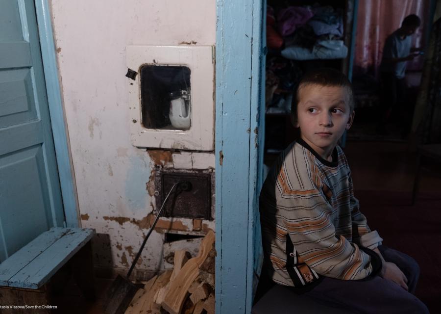bambino ucraino seduto in camera che guarda alle sue spalle