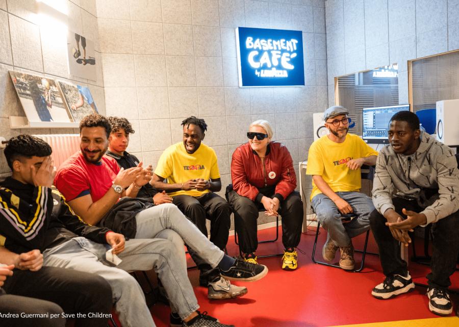 Cantante BigMama seduta con ragazze e ragazzi di CivicoZero Torino di Save the Children 