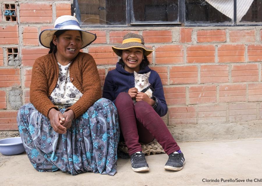Donna e bambina in Bolivia sedute per terra, sorridenti