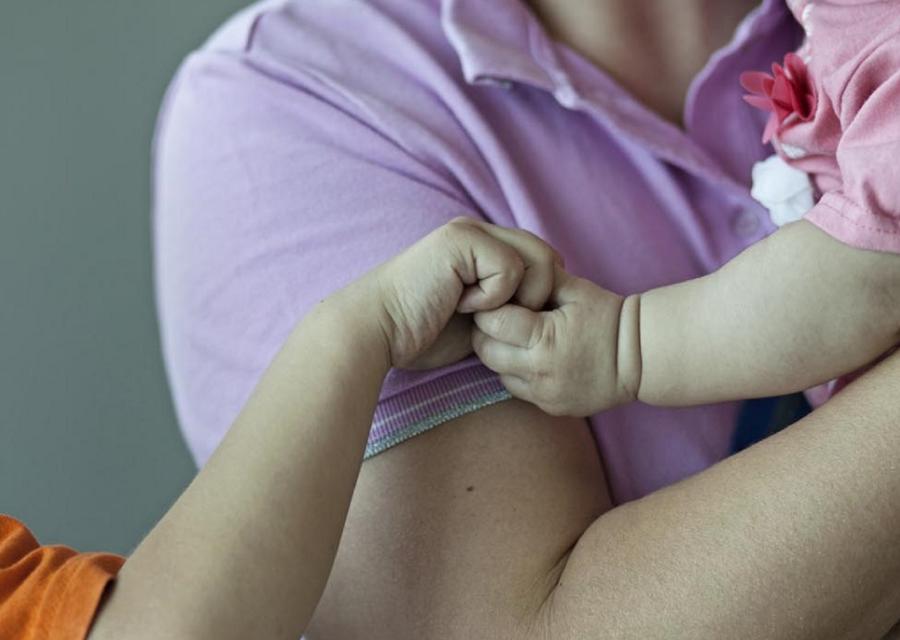 bambino in braccio alla mamma che tiene per mano un altro bambino