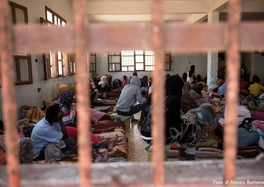 Migranti in stanza sovraffollata dietro le sbarre in centro di detenzione in Libia