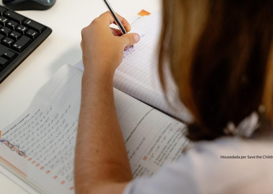 dettaglio di braccio e mano che scrivono su un quaderno di scuola