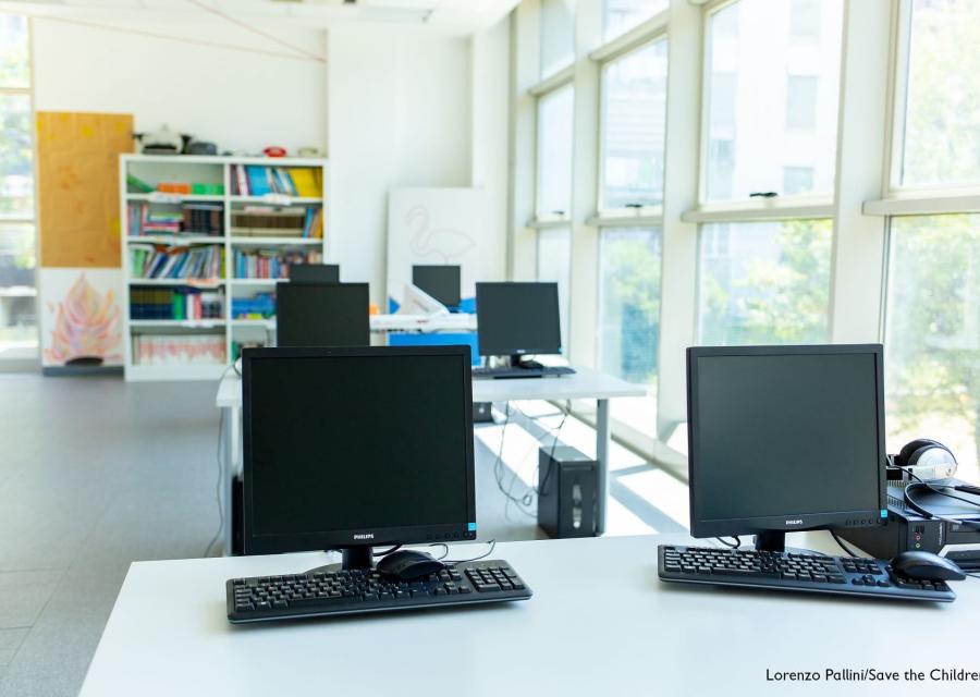 Grande sala di un Punto Luce con computer sui tavoli per le attività educative