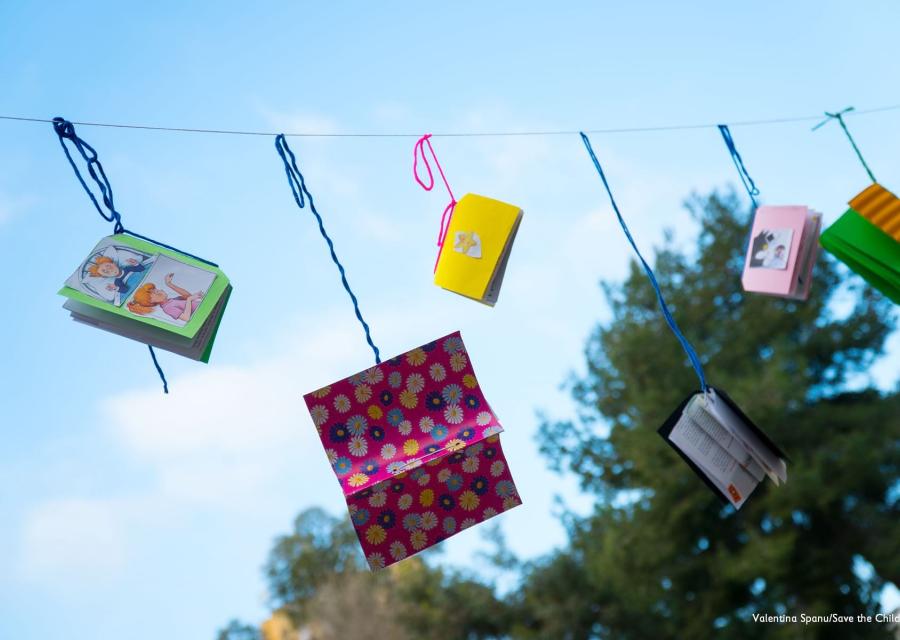 Libri e quaderni colorati appesi a un filo che si stagliano su cielo azzurro
