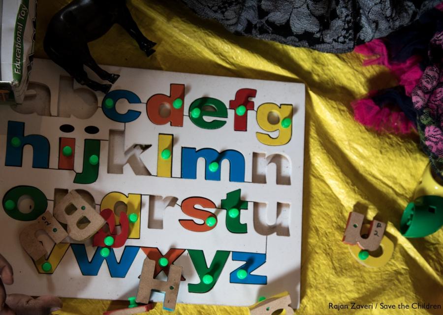tabellone per bambini con lettere dell'alfabeto colorate estraibili poggiato su un lenzuolo giallo
