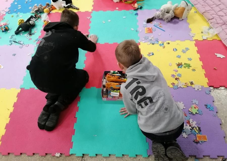 due bambini che giocano su un tappetino colorato pieno di giochi