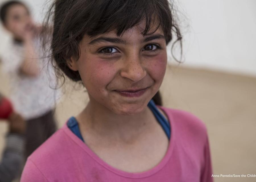 Primo pano di bambina bionda con capelli biondi legati e sguardo sorridente