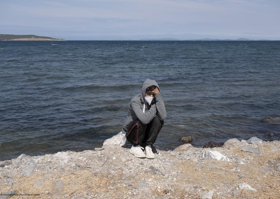 ragazzo seduto sulla sponda del fiume