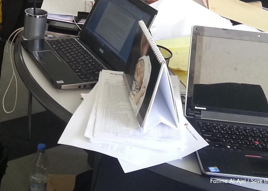 Due laptop appoggiati su un tavolo pieno di carte.