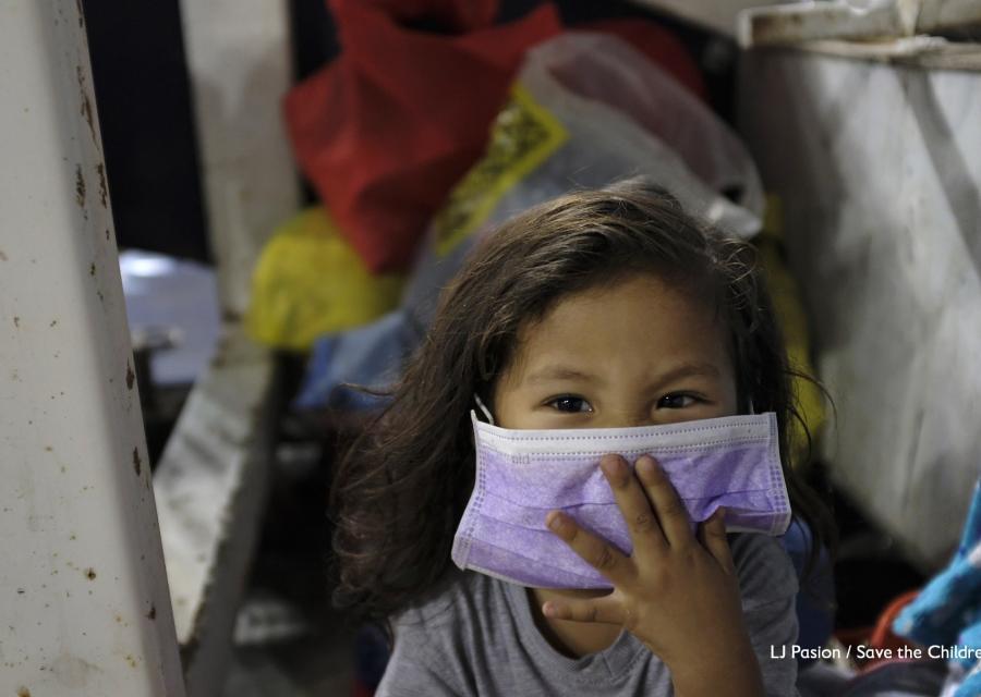 Bambina asiatica con mascherina viola sul viso