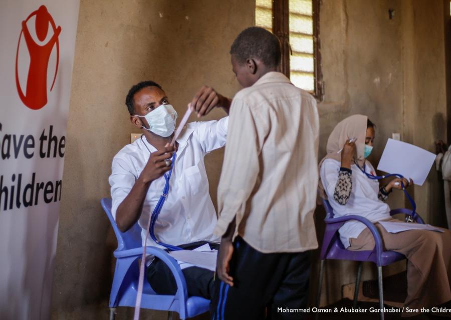 Sudan un operatore con mascherina visita un bambino in piedi di fronte a lui