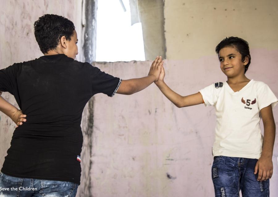 due ragazzi in piedi si danno il cinque con la mano
