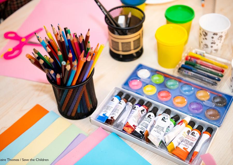 tavolo con pastelli colorati e tempere per fare attività manuali per bambini