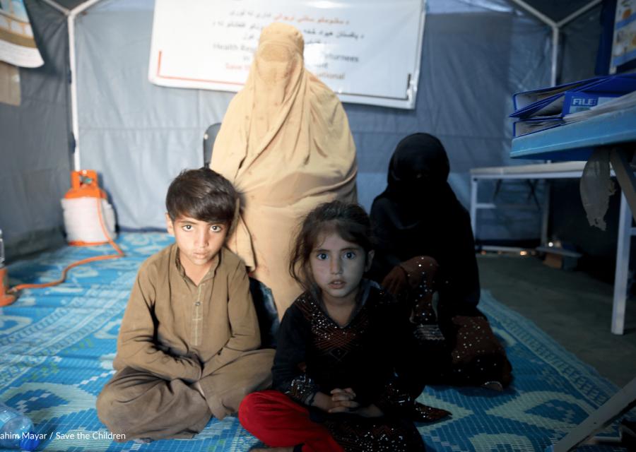 bambini e donne in Afghanistan seduti su tappeto