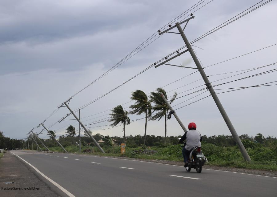 strada con palme piegata da una tempesta e un motorino sulla strada