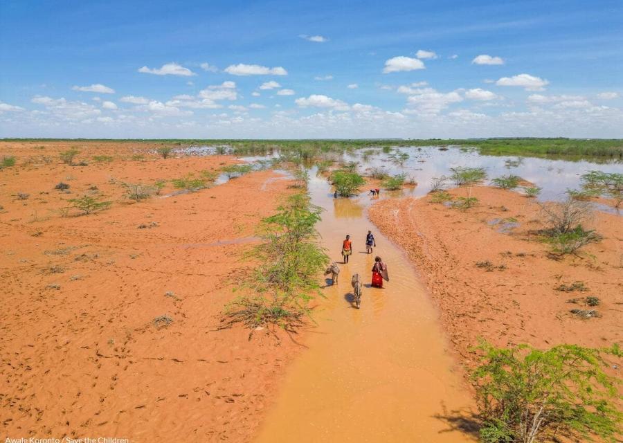 visuale dall'alto di terreno arido con persone che camminano su strada